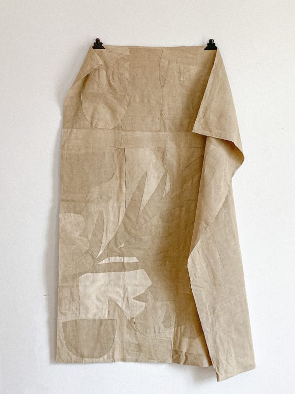 tan linen cloth embroidered with leaves and abstract shapes