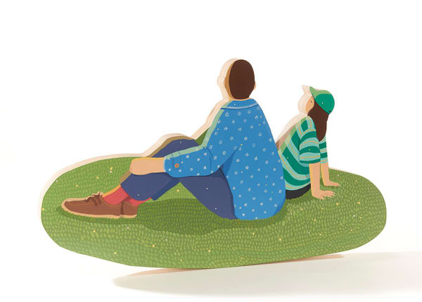 sculpture of two people sitting on a grass patch