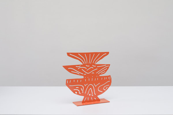 Metal sculpture of three plates stacked on top of each other with a design