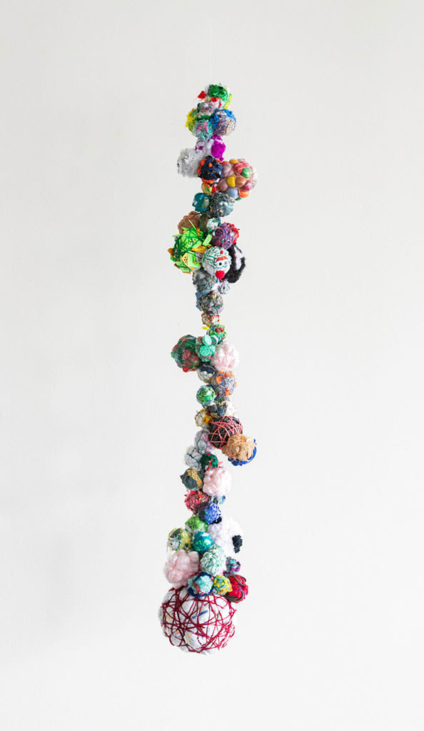 Hanging sculpture of miscellaneous items bound by a string