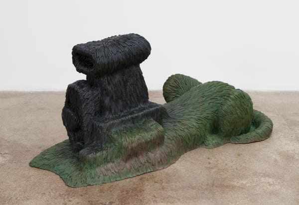Free-standing bronze sculpture of an lion-like animal body and machine-like engine for the head resembling the Sphinx. The sculpture is cast with a surface texture resembling shaggy hair and treated with a green patina that gradually turns black, from bottom to top.