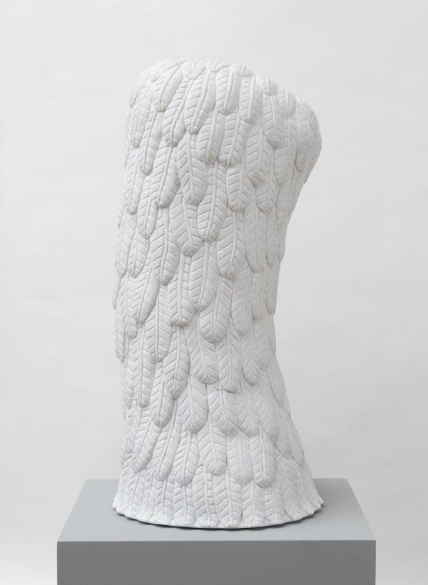 Free-standing, white marble sculpture in the form of a tall, slightly curved column whose entire surface is carved with feathers.