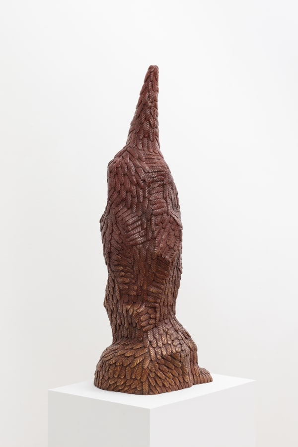 Free-standing bronze sculpture of a form resembling a penguin whose beak is directed upward. The sculpture is cast entirely in feathers and treated with a maroon and gold patina.