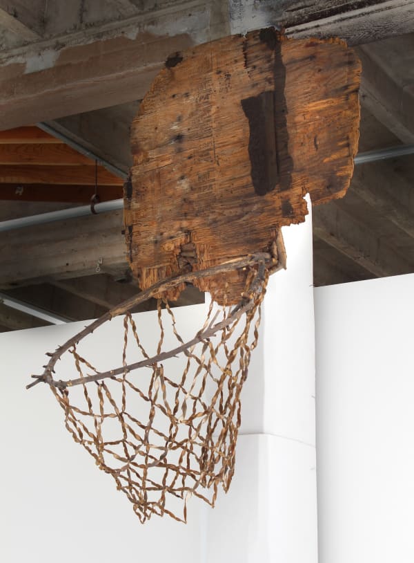 Sculpture of a broken basketball hoop made from found wood branches and wisteria seed pods