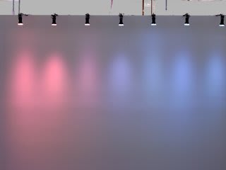 Still image of several black spotlights sticking out from the top of a white wall and pointing downward The LEDs in the spotlights shine multi-colored lights reflecting down the surface of the wall in elongated ellipses