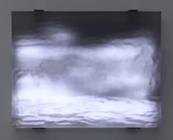 Still image of resin carved to depict wave forms illuminated from behind with white LEDs