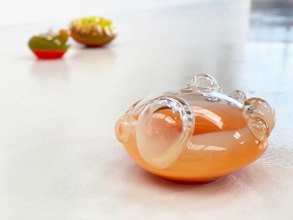 Three glass blown sculptures arranged on a white floor.