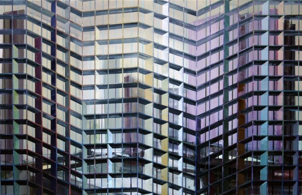 Abstract urban landscape with several blurry and colorful high rise buildings A multi-colored grid of alternating thin and thick horizontal and vertical lines form the illusion of foreground scaffolding