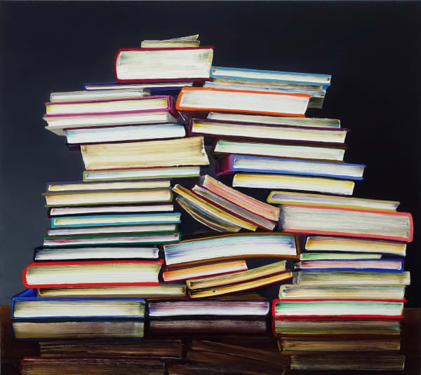 Precarious stack of books with colorful covers creates a pyramid shape against dark background.