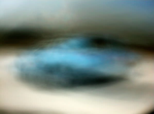 Light box depicting heavily blurred image of light blue car driving
