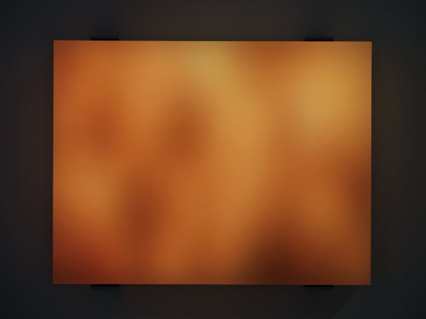 Still image of orange and yellow LEDs blurred behind thick block of resin