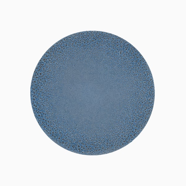 Against a white background, blue and black circle is made of tiny dots. Towards the center of the circle, dots become smaller and denser, creating the appearance of a solid blue color.