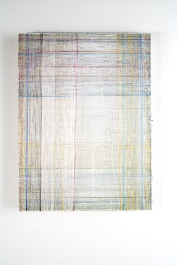 Layers of multi-colored threads strung across a rectangular wooden and plaster panel create the effect of a pastel plaid pattern enclosing a soft white glowing background