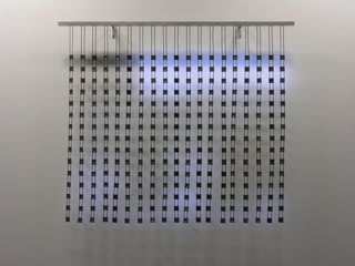 Still image of multiple large hanging white LED strips attached to a long horizontal metal pole The LEDs light the wall behind them with blurred scenes taken from old family home movies