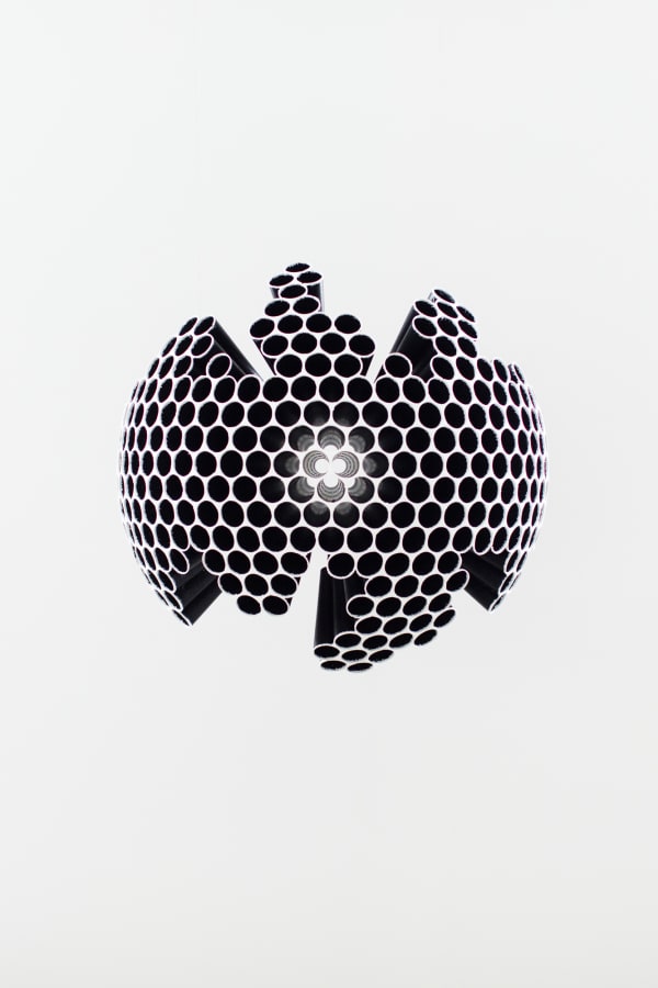 Multiple hollow aluminum tubes or various lengths stacked and arranged to form a globe that acts as a distorted lens