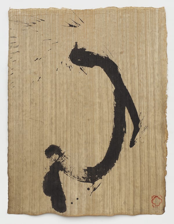 Hasty black ink brush that curves left and splatters on brown textured paper