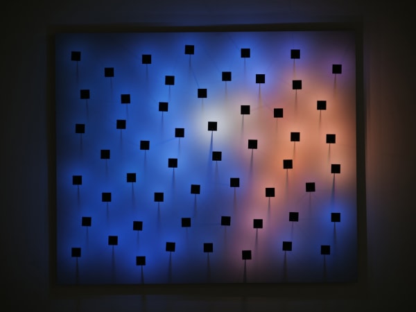 An image of scattered black pegs with a colorful background.