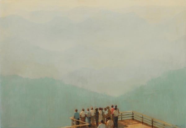 A group of people standing on a wooden deck overlook a clouded scene of mountains and open sky.