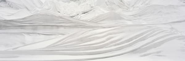 Digital panoramic landscape photograph of bright white tarps blanketing the rough multiple ridged surface of the Swiss Rhône Glacier during the day