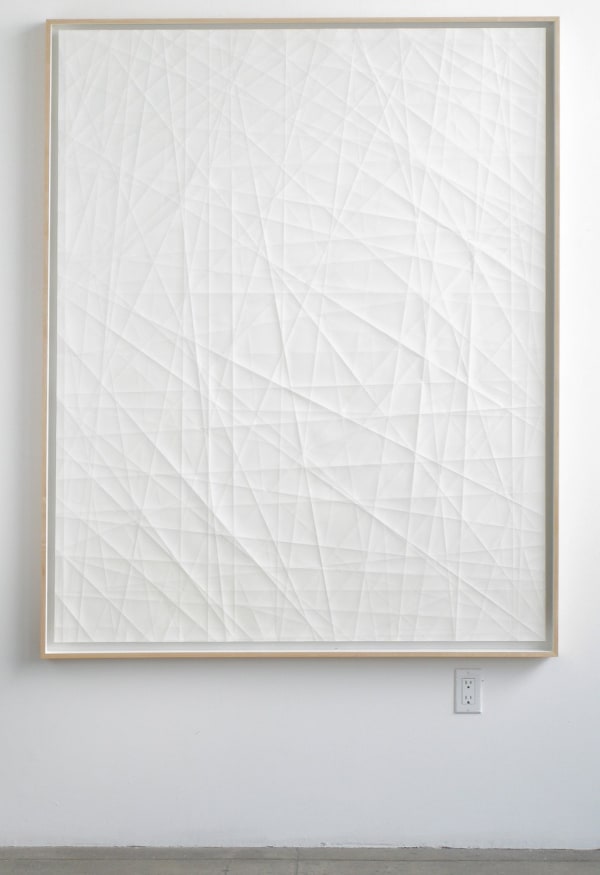 Light watercolor wash on large paper with folds contained in a beige wooden frame