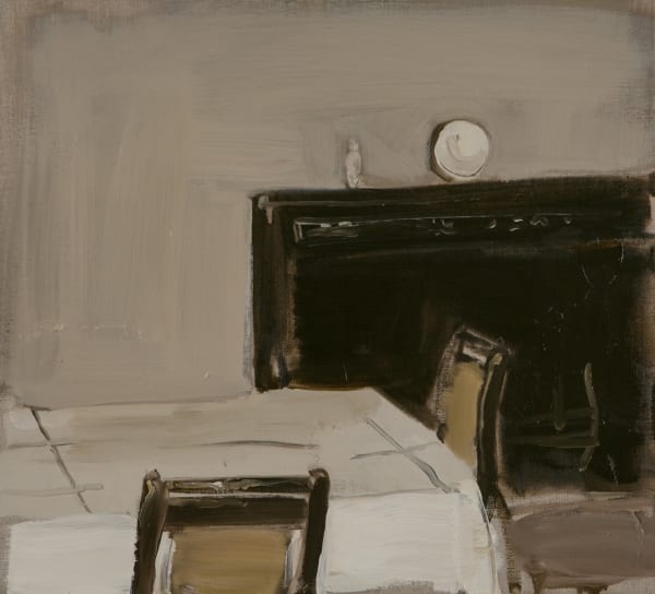 Corner of a table with white table cloth and two chairs in front of black mantelpiece.
