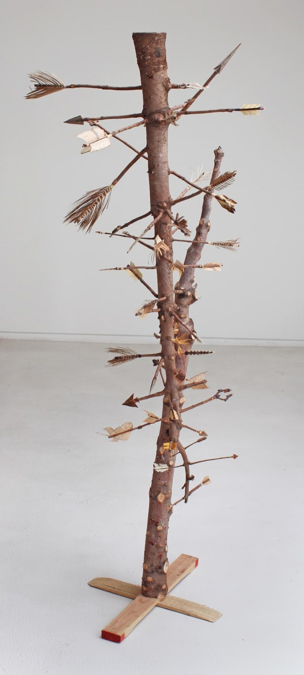 Two old christmas trees with few bare branches which have been turned into arrows with household and found items such as seeds, dried leaves, food scraps, and twine. The sculpture referencing the popular Italian Renaissance and Christian subject of Saint Sebastian who was often depicted with multiple arrows shot through his body