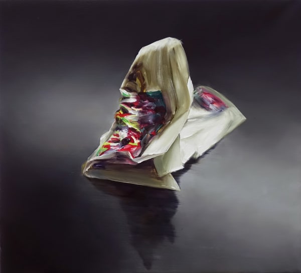 Against gradient gray background, crumpled piece of paper with bright neon abstract image in shades of green and fuschia.