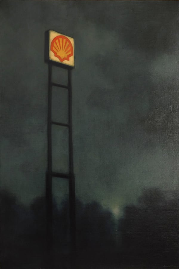 Sign for Shell (oil and gasoline company) rises above trees into a cloudy night sky.