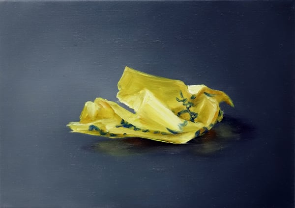 One crumpled yellow Post-it note with blue writing against dark gray background.