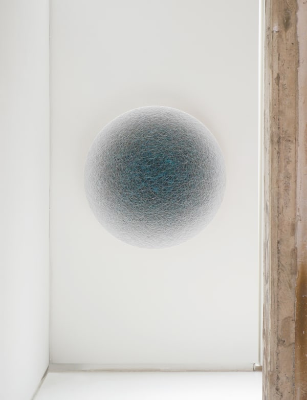 Closer hallway view of a blue ombre circle, fading from dark blue to white from the center.