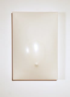 Smooth plaster with a small nob near the bottom center of the piece to represent a navel The entire piece is coated with wax to create a glazed effect