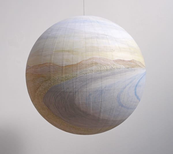 Ballpoint pen drawing with washes of blue yellow and orange acrylic create a hilly beach landscape on paper which is pasted onto a large fiberglass hanging globe. Throughout most of the sandy landscape various thoughts are scribbled down in all caps