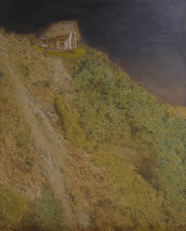 White A-frame cottage sits atop cliff covered in dense foliage. Cottage seems to glow against dark night sky.
