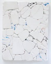 White plaster and plastic pieces pressed onto to form crumbly surface with blue paint in the cracks