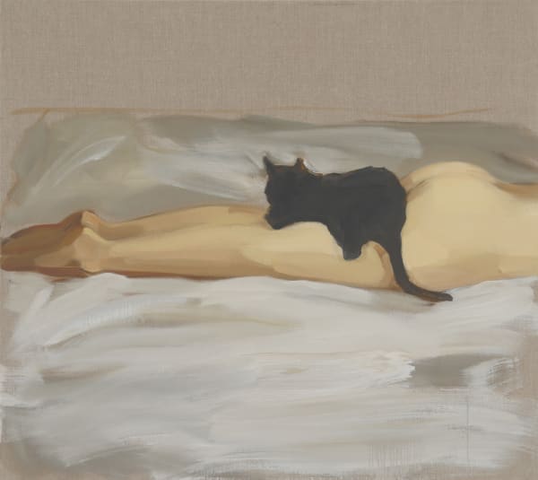 Black cat lies on top of woman’s nude legs as she lies face down on a bed. Her upper body is cropped out of the composition.