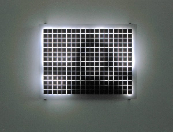 Still image of a rectangular piece with multiple white LEDs behind Plexiglass with grid of black squares on its surface that displays blurred scenes taken from old family home movies