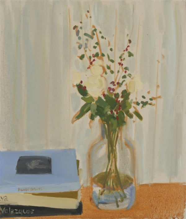 Flowers in vase to the right of three stacked books on orange surface in front of beige wall.