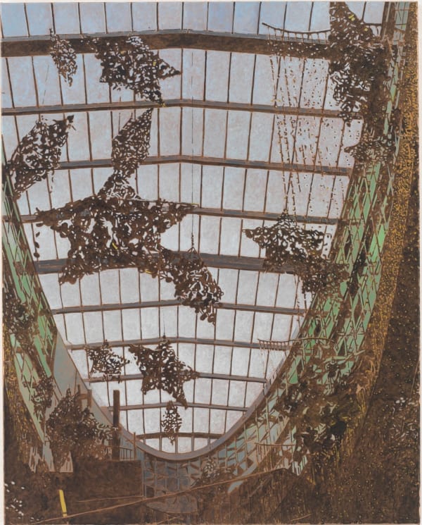 Glass ceiling of modern, industrial, oval-shaped building. Hanging from ceiling are several large star-shaped art pieces.