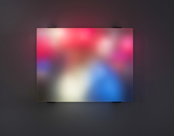 Still image of multiple multi-colored LEDs blurred behind thick block of resin show people walking through a crowd in the twenty seventeen Women’s March in Washington DC