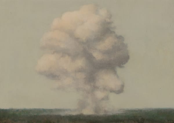 Giant cloud of smoke erupts from tiny forest landscape into expansive gray sky.