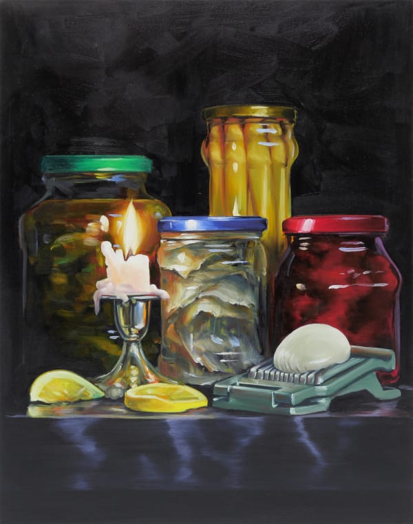 Still life of lit candle, two lemon slices, four jars of preserved vegetables and a mandolin slicer with round white vegetable.