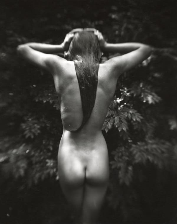 Jessie Mann standing nude facing away from the camera with her hands on her head, from Sally Mann Immediate Family series