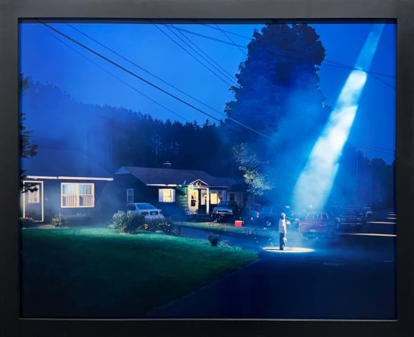 man holding six pack of beer on suburban street at night with beam of light shining down on him by Gregory Crewdson from Twilight series