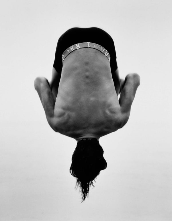 Herb Ritts photograph of man upside down mid air, in a backflip in Paradise Cove
