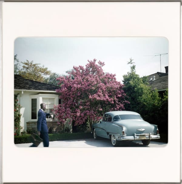 Artist, Omar Diop walking to a vintage car parked in a driveway. By Lee Shulman & The Anonymous Project.