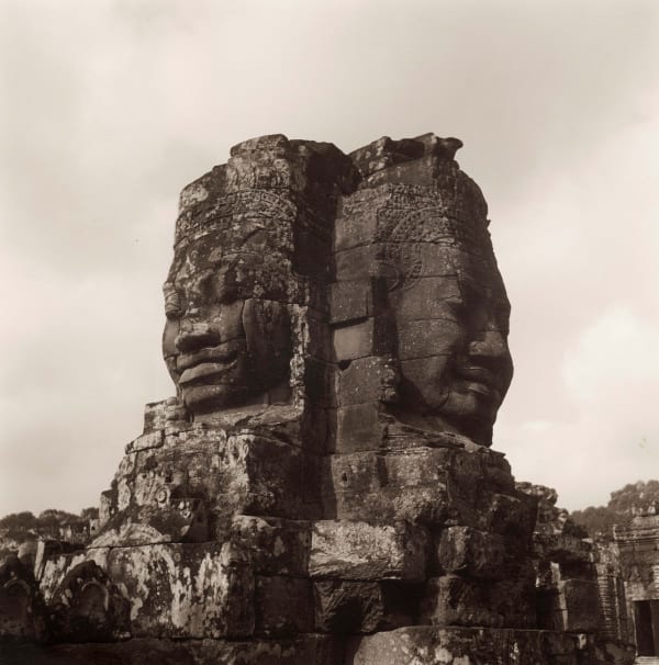 Lynn Davis photograph of two heads carved from mountain at the Bayon, Angkor Wat, Cambodia