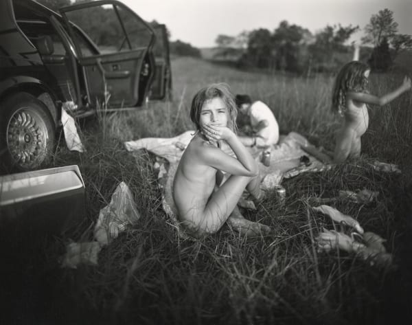 Three children having picnic in the grass after Monet's Luncheon on the Grass by Sally Mann
