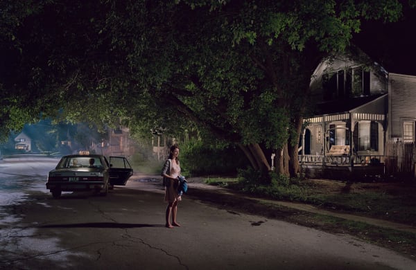 Woman standing on street at night with taxi with door open by Gregory Crewdson