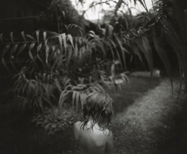 Virginia with wet hair and Arundo donax plants in background, from the Immediate Family series by Sally Mann