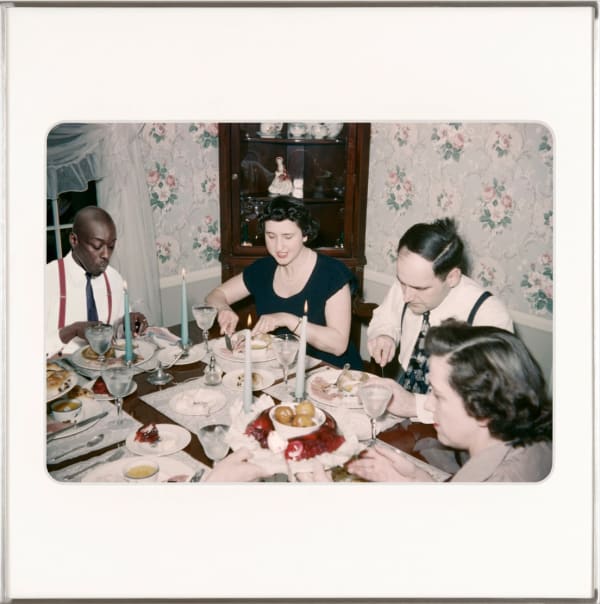 Omar Diop sitting at a holiday dinner table with three other white people. By Lee Shulman & The Anonymous Project.